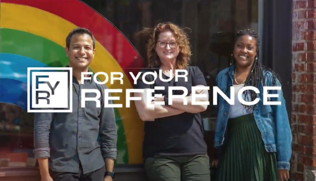 Three people standing in row leaning on a window with rainbow decal.