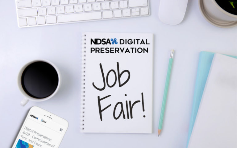 Color photo of top down view of white desk with white keyboard, full coffee mug, cell phone, and note pad. On note pad: NDSA DigiPres logo and handwritten words "Job Fair!"