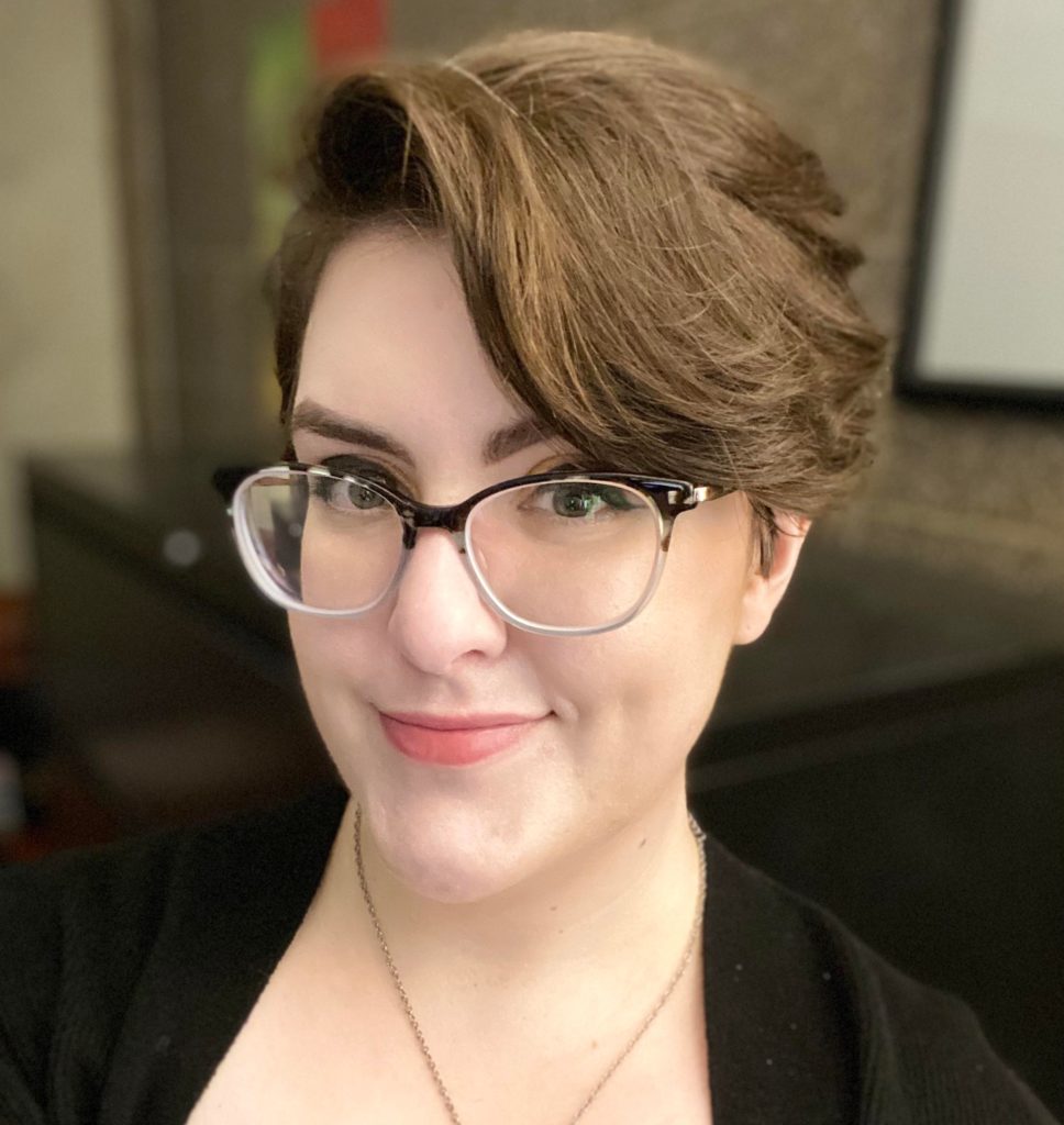 Color photo headshot of Martin-Gant wearing glasses and dark cardigan.