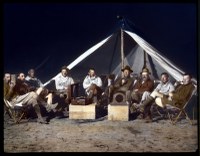 Circ. 1921-1930: Expedition group seated, enjoying Victrola, Third Asiatic Expedition, Gobi Desert, Mongolia.