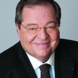 Color headshot photo of Guy Berthiaume wearing dark suit, tie, and white shirt.